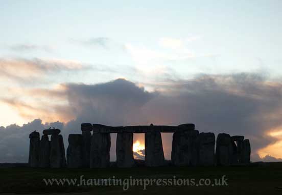 Stonehenge with crow - sun sets behind Sarsens